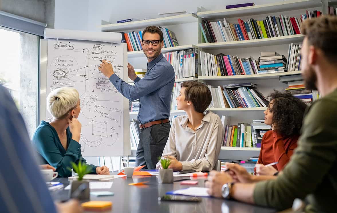 image of a group of people talking while pointing to a chart
